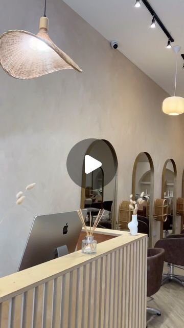 the interior of a salon with chairs, mirrors and laptops on display in front of them