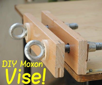 a wooden table with two metal handles and the words diy moxon vise on it