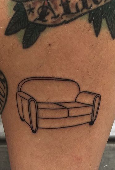 a tattoo on the leg of a person with a couch drawn on it's side