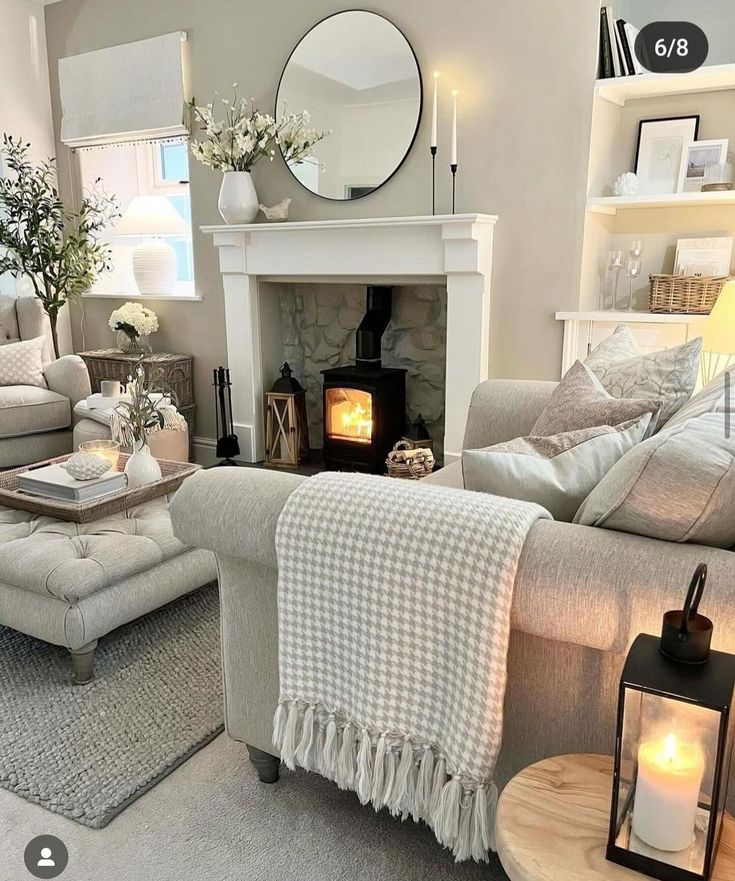 a living room filled with furniture and a fire place next to a mirror on the wall