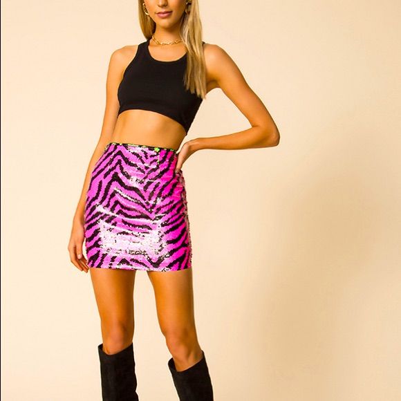 a young woman is posing for the camera wearing a pink and black zebra print skirt