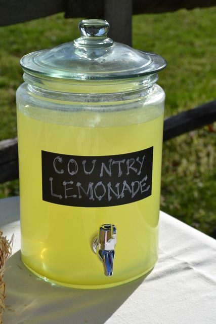 a yellow jar sitting on top of a white table next to a straw ball and fence