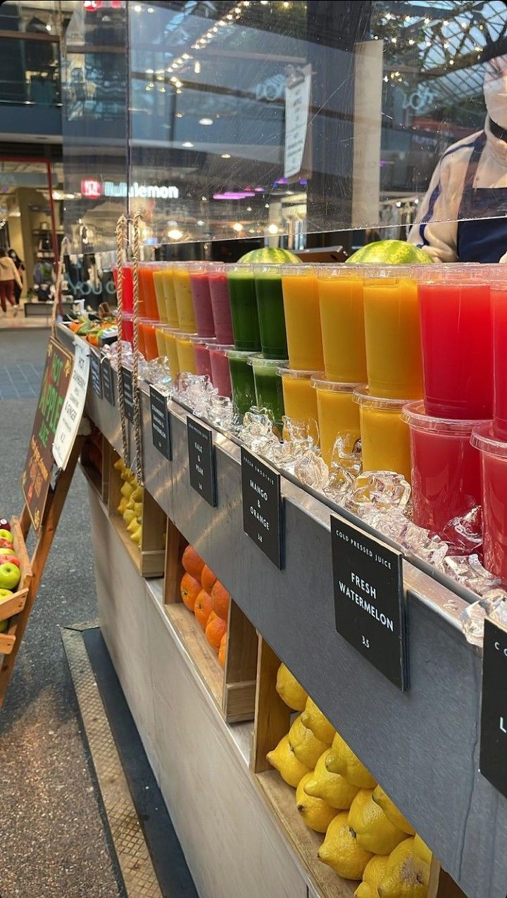 a display in a grocery store filled with lots of different colored juices and smoothies