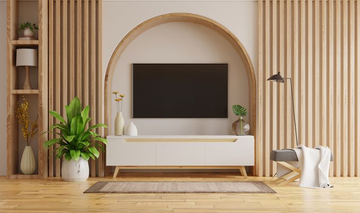 a living room with a large screen tv on the wall and wooden shelves in front of it