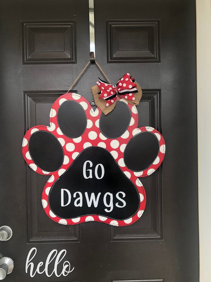 a door hanger that says go dawgs with a dog's paw on it