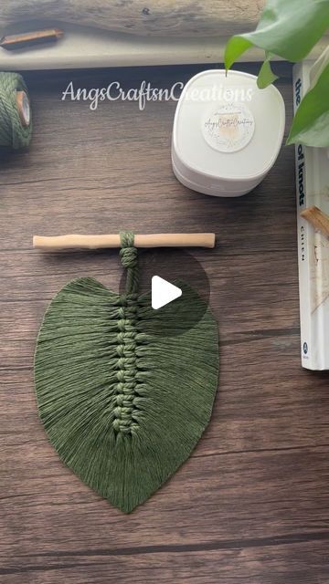 a green heart hanging from a string on top of a wooden table next to other items