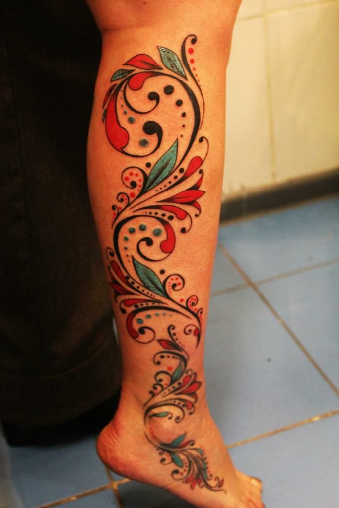 a woman's leg with an artistic tattoo design on the lower part of her body