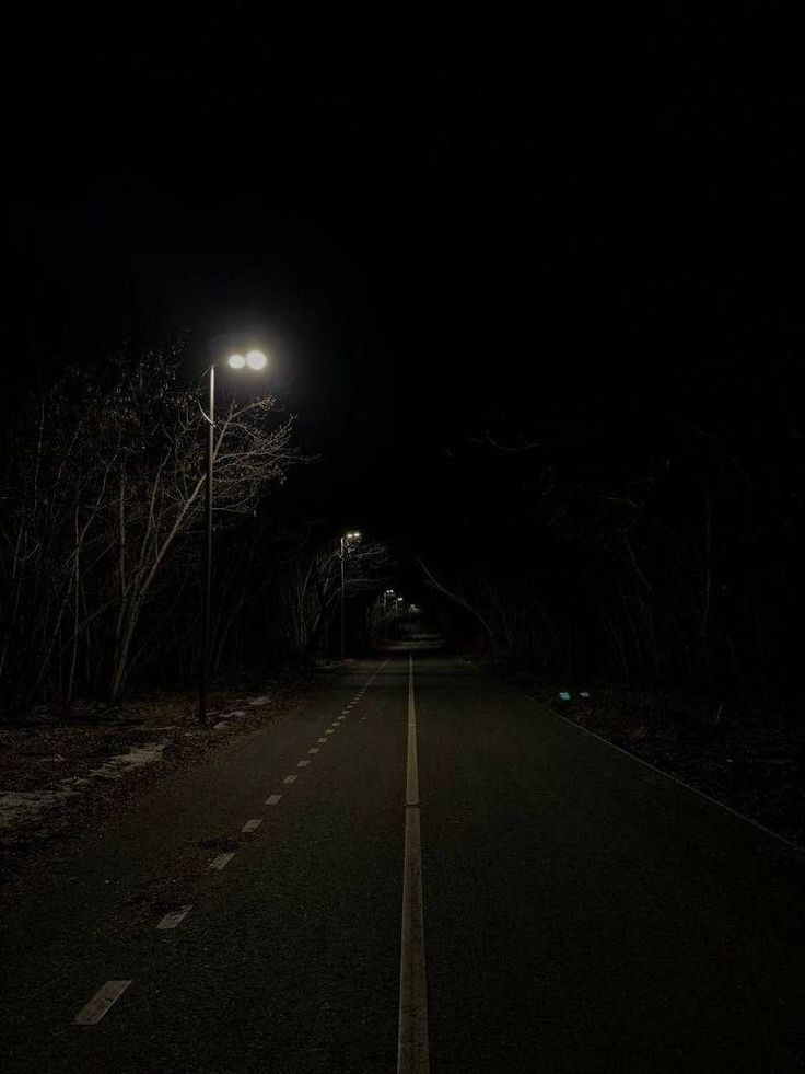 an empty road at night in the dark