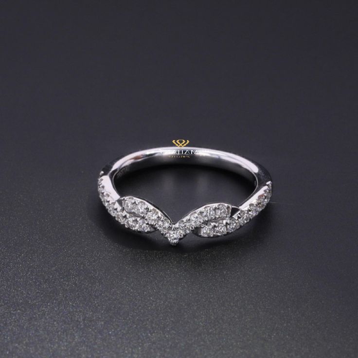 a white gold and diamond ring on a black surface