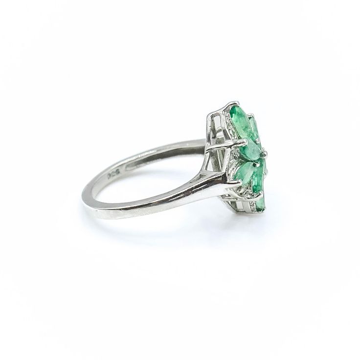 Sterling Silver Emerald Floral Ring Size 5. This Platinum plated Sterling Silver ring features eight marquise cut green Emerald stones prong set in a floral pattern. This makes a great birthday gift for a young lady. Emeralds symbolize love and truth and they are also the May Birthstone. Green is the color of life. It is often associated with nature, health, growth and prosperity. It represents hope for the future.Ring is pre-owned and in great condition. Buy with confidence knowing that all our Marquise Birthstone Ring For Formal Occasions, Vintage May Birthstone Rings, Vintage Green Birthstone Ring For Anniversary, Cluster Ring With Marquise Cut As Gift, Green Marquise Diamond Ring For Formal Events, Green Cluster Ring For May Birthstone Formal Occasion, Vintage Green Birthstone Ring For Wedding, Vintage Green Birthstone Wedding Ring, Green Marquise Diamond Ring For Formal Occasions