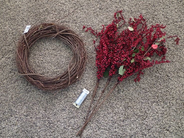 a bunch of red flowers sitting on top of a floor next to a wire wreath