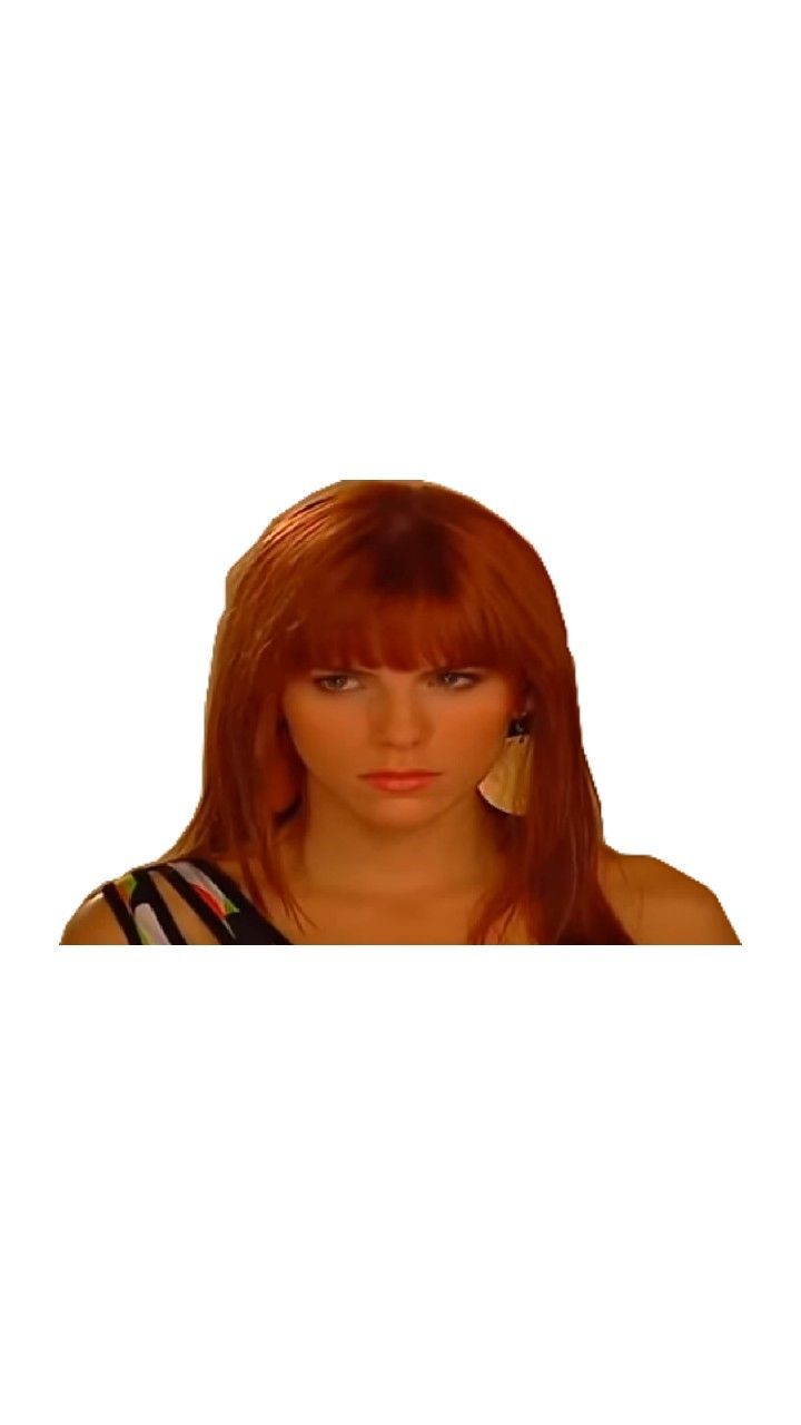 a woman with long red hair is looking at the camera