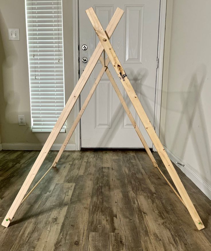 a large wooden frame sitting on top of a hard wood floor next to a door