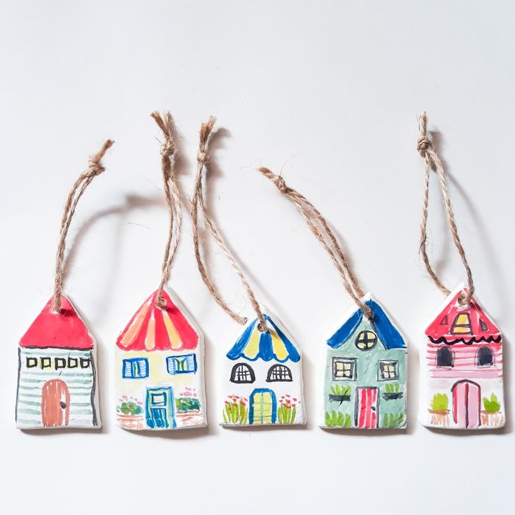 four hand painted wooden houses hanging from twine