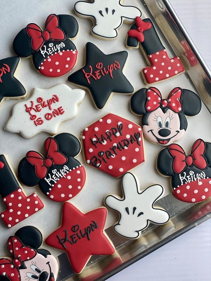 decorated cookies in the shape of mickey and minnie mouses are displayed on a tray