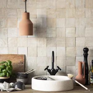 a bathroom sink sitting next to a wooden counter top under a hanging light above it