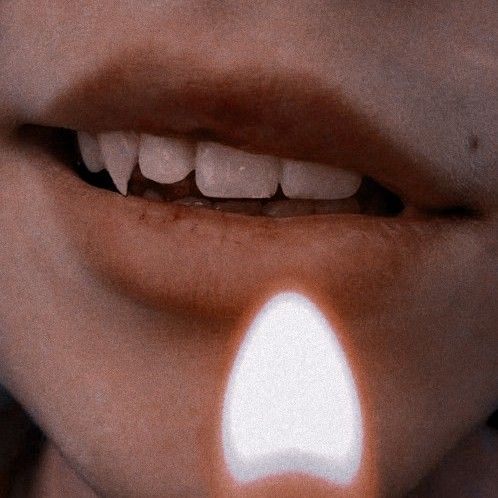 a woman's lips with white light coming out of the top part of her mouth