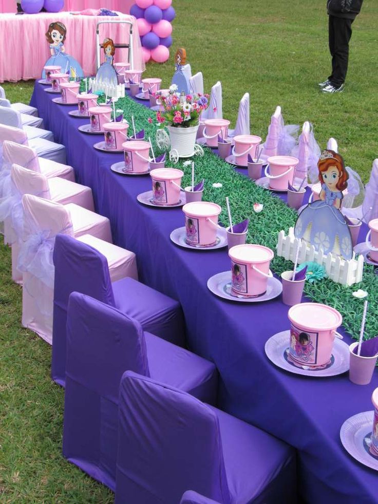 a table set up for a princess party with pink and purple decorations on it's tables