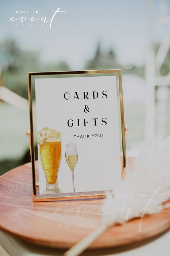 there is a sign that says cards and gifts on the table next to two wine glasses