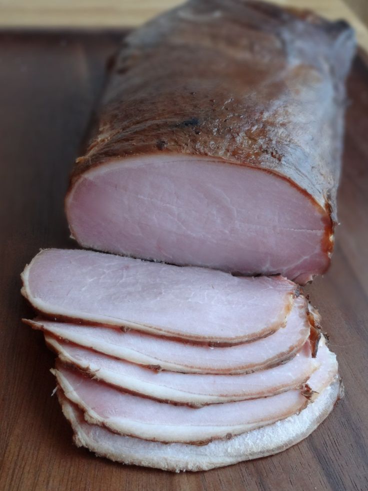 sliced ham sitting on top of a wooden cutting board