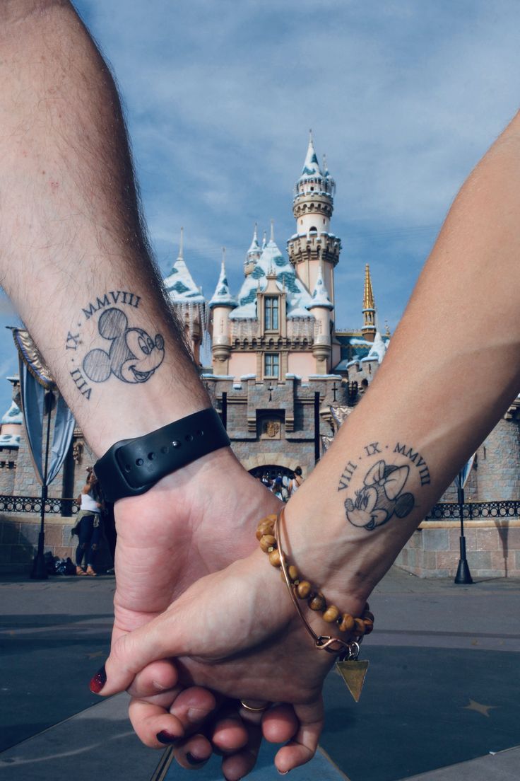 two people holding hands in front of a castle