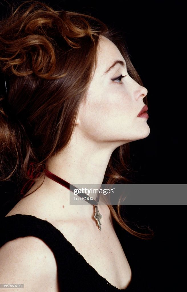 a woman with her eyes closed wearing a choker and black dress, looking off to the side