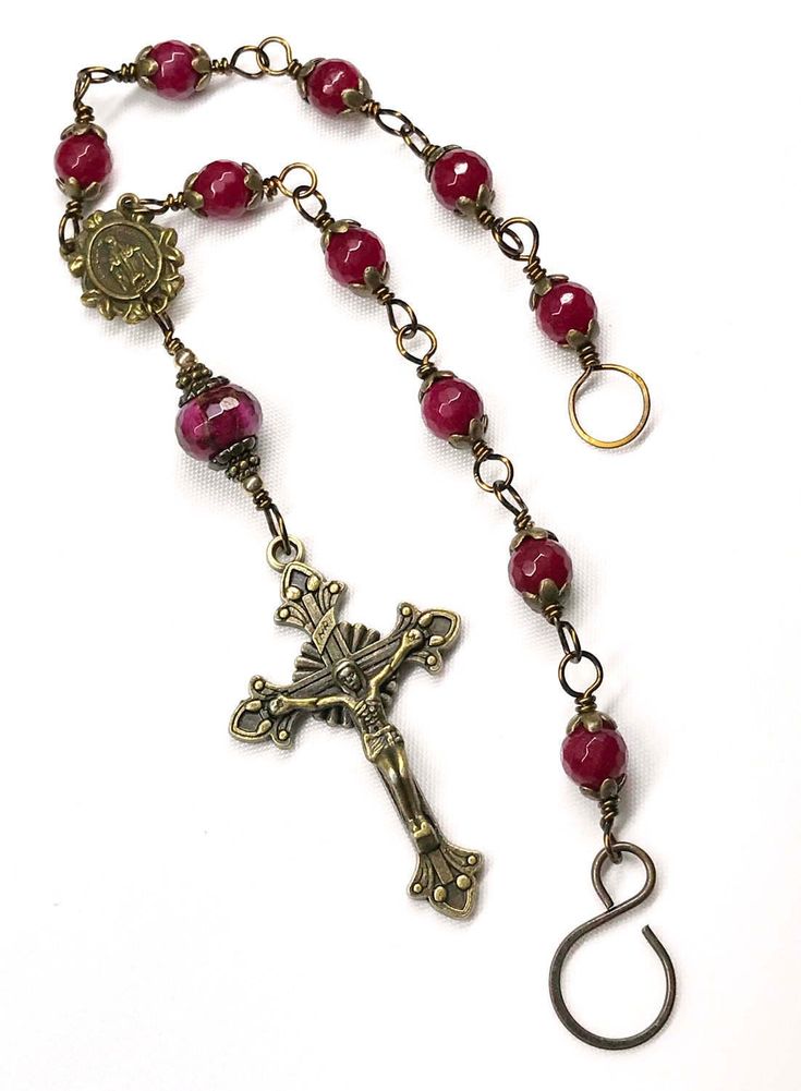 "This beautiful Rosary is made with a Starburst Vintage Bronze Crucifix, and Vintage Bronze Miraculous Medal center. It is completely wire wrapped in Vintage Bronze Wire, with eleven exquisite 8 mm faceted ruby red jade gemstone beads, and 22 Vintage Bronze bead caps. The Our Father bead is a 12 mm faceted Ruby Red & Gold pressed jade roundel. I used NO JUMP RINGS in the making of this rosary, thus it is a durable rosary that is made to last a lifetime! Pictures do not show the absolute bril Adjustable Beaded Rosary For Blessing, Adjustable Red Rosary With 8mm Beads, Vintage Adjustable Rosary With Round Beads, Vintage Adjustable Rosary, Adjustable Crucifix Rosary, Adjustable Red Beaded Rosary, Beautiful Rosary, Pocket Rosary, Red Jade