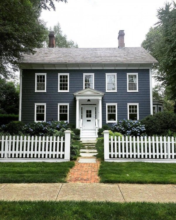 a blue house with white picket fence around it