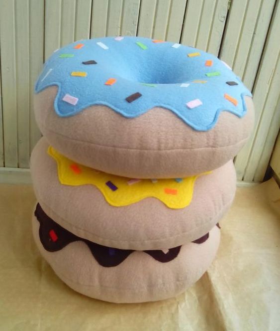 three pillows stacked on top of each other with donuts and sprinkles