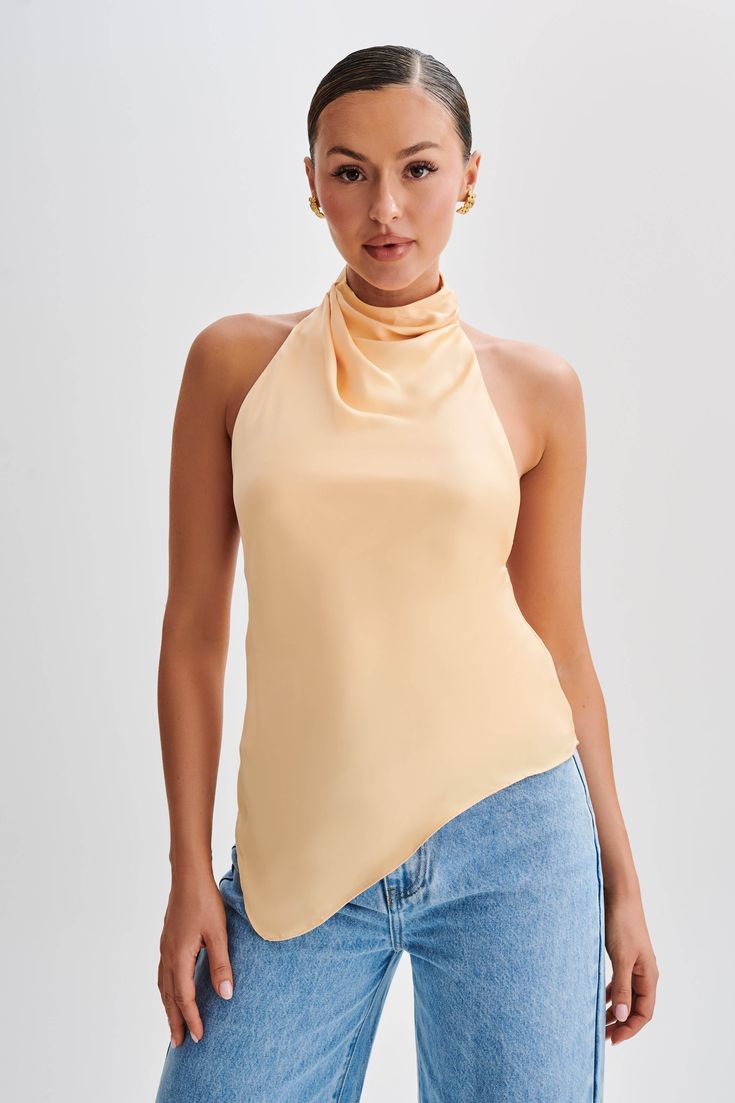 Elevate your everyday.Introducing the SERAPHINE Satin Halter Top, a vision of elegance and allure. Crafted to perfection, this top features a stunning halter neckline adorned with a graceful cowl detail, adding a touch of sophistication to your look. The low back design exudes understated glamour, while the asymmetrical hemline adds a modern twist. Complete with a delicate button closure at the neckline, it ensures a secure and stylish fit. Lined for comfort and coverage, this top promises a lux Spring Party Top With Cowl Back, Elegant Party Halter Top With Cami Shape, Elegant Cami Halter Top For Party, Elegant Party Halter Top Cami, Spring Party Tops With Cowl Neck, Spring Party Cowl Neck Top, Evening Halter Neck Top For Spring, Spring Evening Halter Neck Top, Halter Neck Tops For Spring Evenings