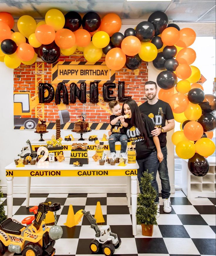 a man and woman standing in front of a table with construction themed decorations