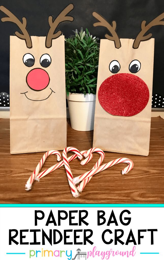 two paper bags with reindeer noses and candy canes in front of them on a table