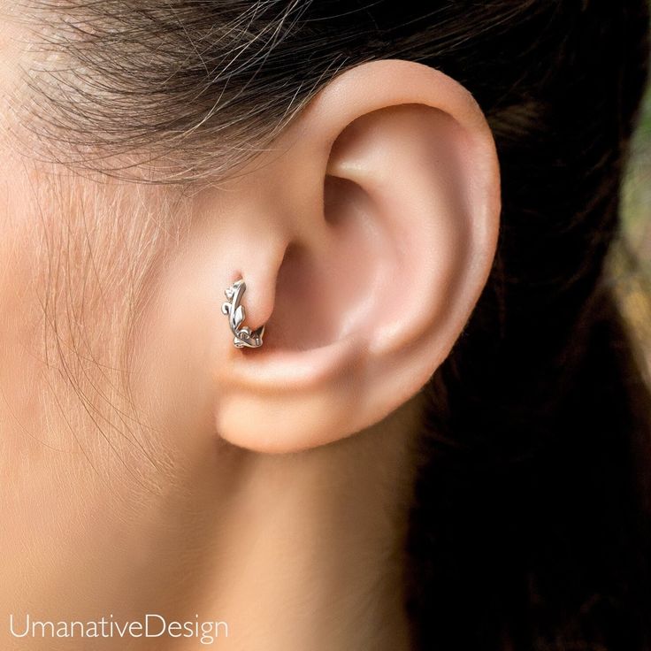 a close up of a person's ear with a diamond ring on top of it