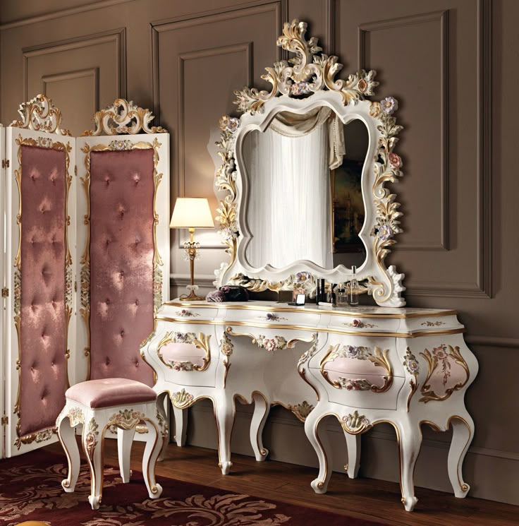 an ornately decorated bedroom with pink and white furniture, gold trimmings and mirrors