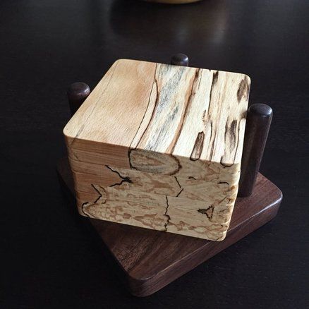 a small wooden box sitting on top of a black table next to a banana peel