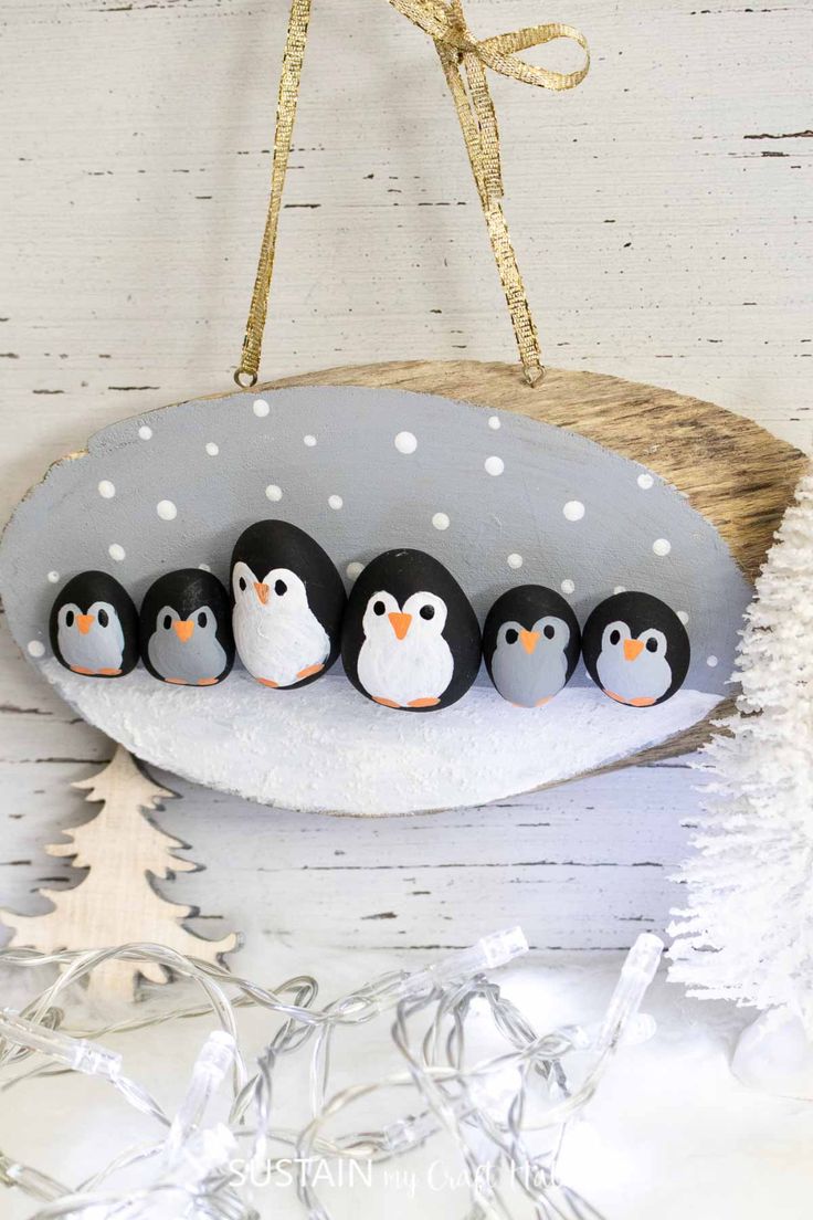 a group of penguins sitting on top of a white plate next to a christmas tree