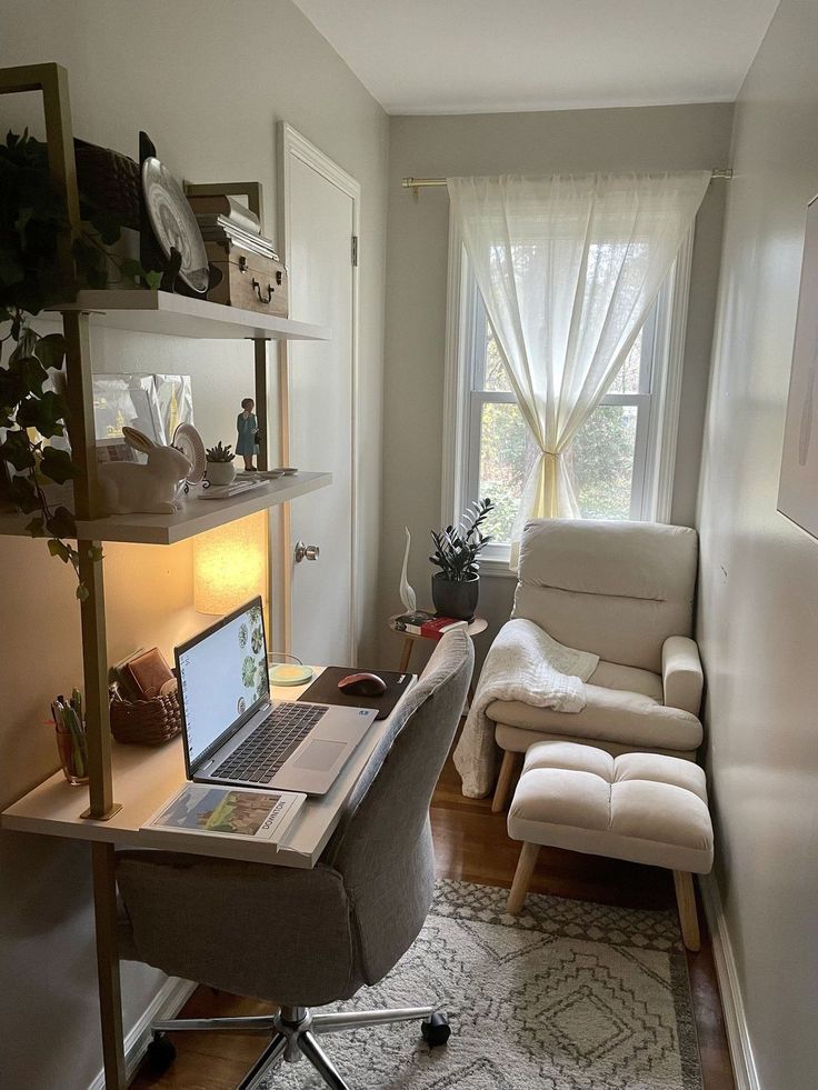 a laptop computer sitting on top of a desk in front of a chair and window