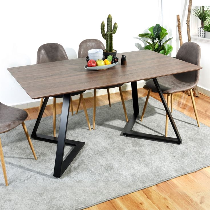 a dining table with chairs around it on a rug in front of a white wall