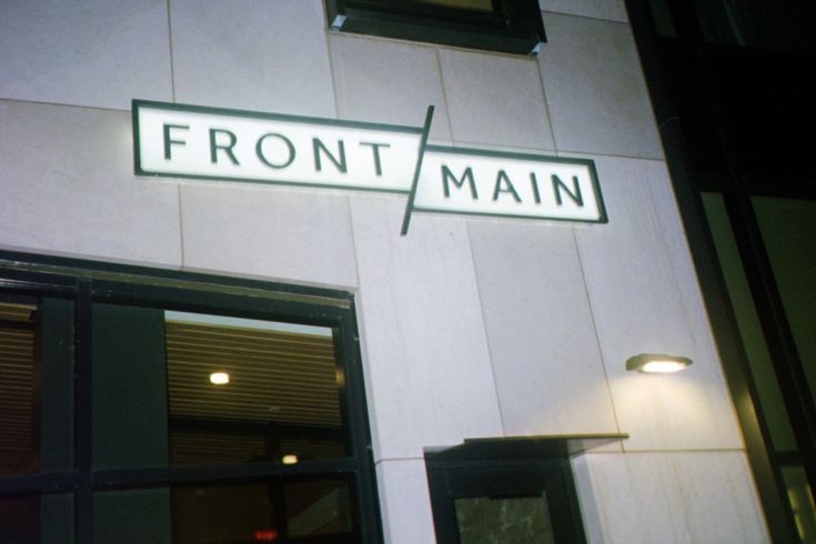 the front and side of a building with a sign that says front main on it