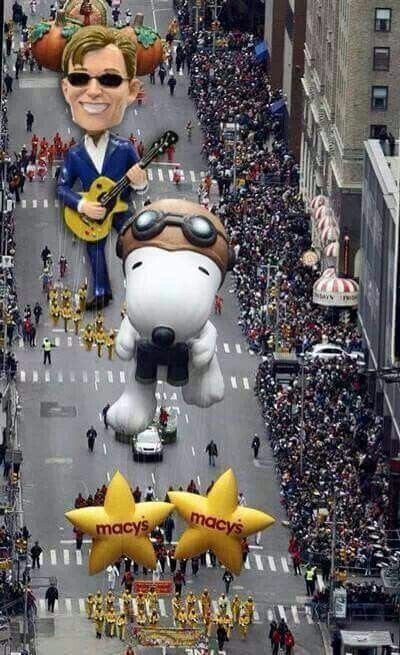 a parade float with large balloons in the shape of snoopy's head and two yellow stars