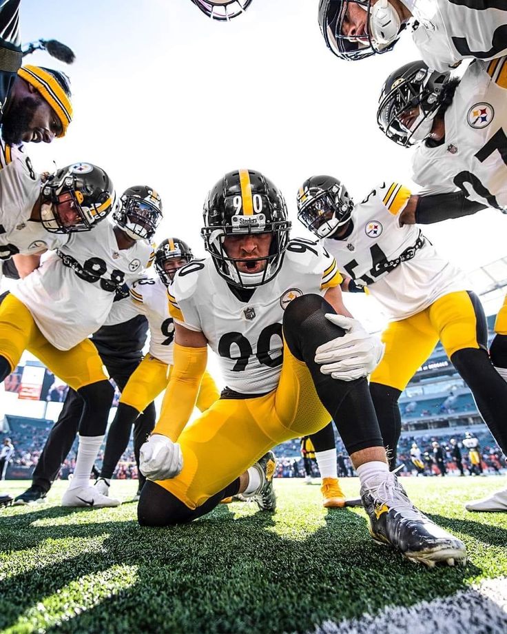 a group of football players standing on top of a field