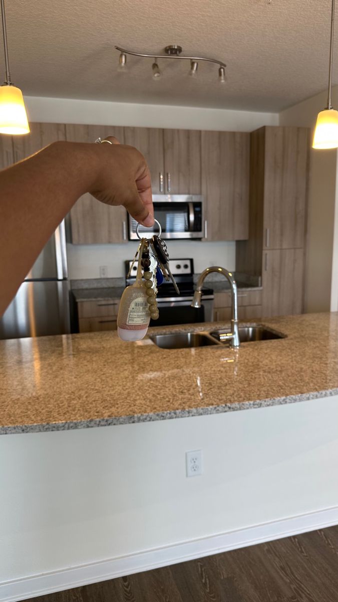 a person's hand is pouring liquid into a bottle on the kitchen counter top