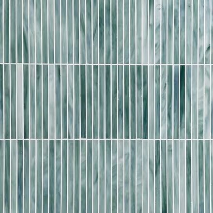 a close up view of a glass tile wall with vertical lines in shades of blue and green