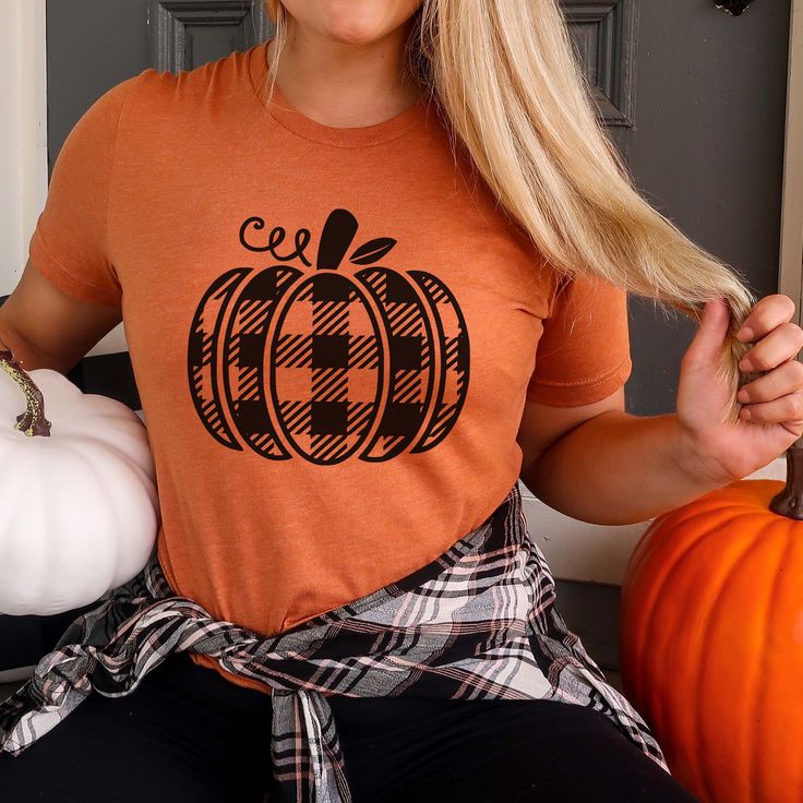 Hey there, autumn enthusiast! Ready to blend cozy comfort with a touch of seasonal style? The Plaid Pumpkin Bella Graphic Tee is perfect for celebrating fall with a classic twist. Whether you're browsing a farmers' market, sipping on a pumpkin spice latte, or enjoying a crisp fall day, this tee brings a stylish and festive flair to your autumn wardrobe. Crafted from ultra-soft, high-quality Bella canvas, the Plaid Pumpkin Graphic Tee offers exceptional comfort and durability. Its relaxed fit and premium fabric keep you cozy and looking effortlessly stylish as you enjoy all the best of fall. Featuring a charming plaid pumpkin design, this tee combines the warm, familiar pattern of plaid with the vibrant appeal of autumn pumpkins. The blend of classic plaid and pumpkin graphics creates a fes Plaid Pumpkin, Pumpkin Graphic, Autumn Pumpkins, Autumn Wardrobe, Fall Day, Cozy Cardigan, Autumn Beauty, Seasons Of The Year, Pumpkin Design