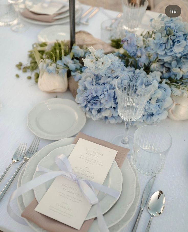 the table is set with blue and white flowers