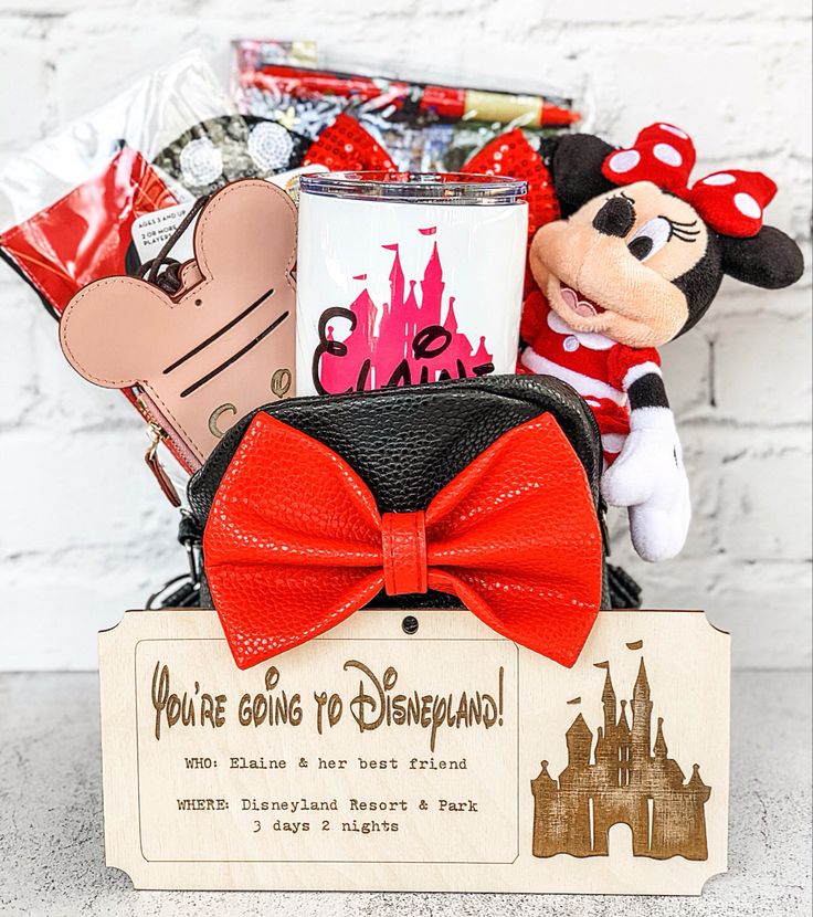 a minnie mouse gift basket with coffee mug, candy and other disney related items in it