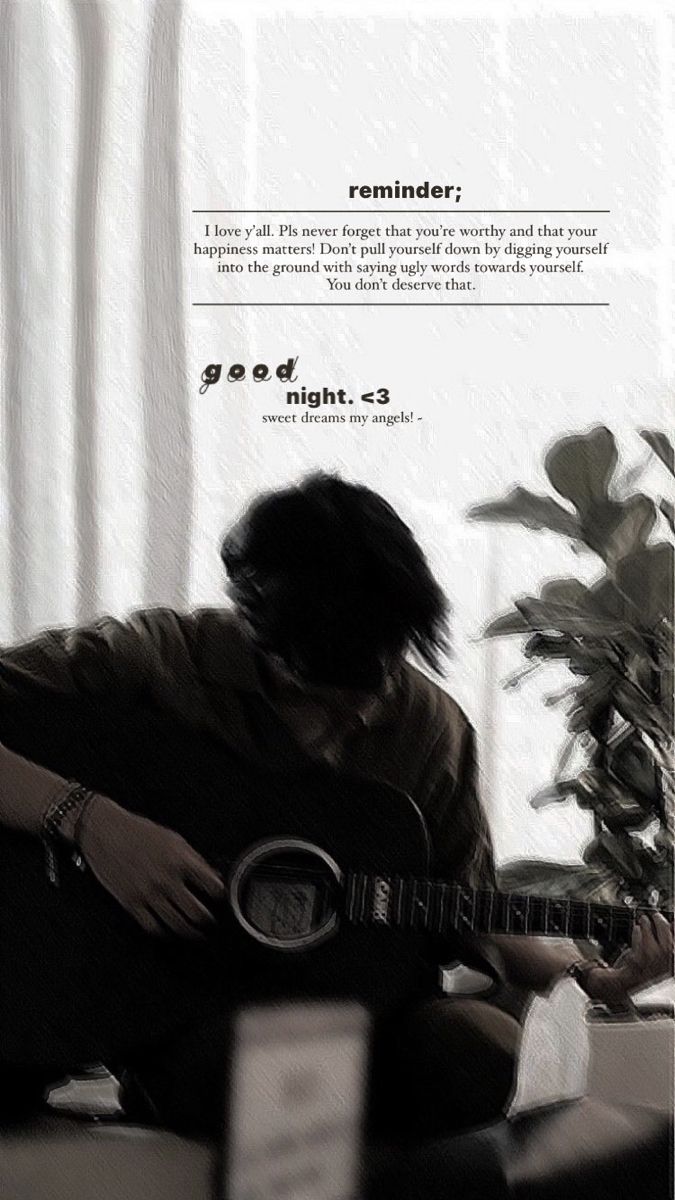 a man sitting on top of a couch holding a guitar next to a potted plant