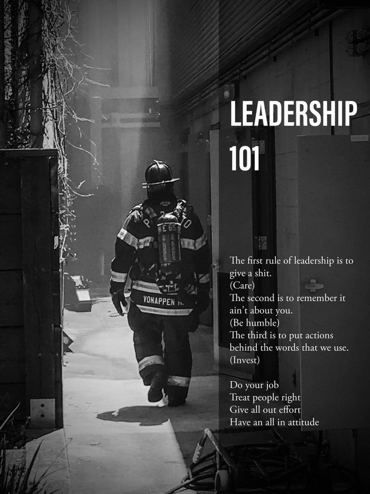 a firefighter is walking down the sidewalk in front of a building with words written on it