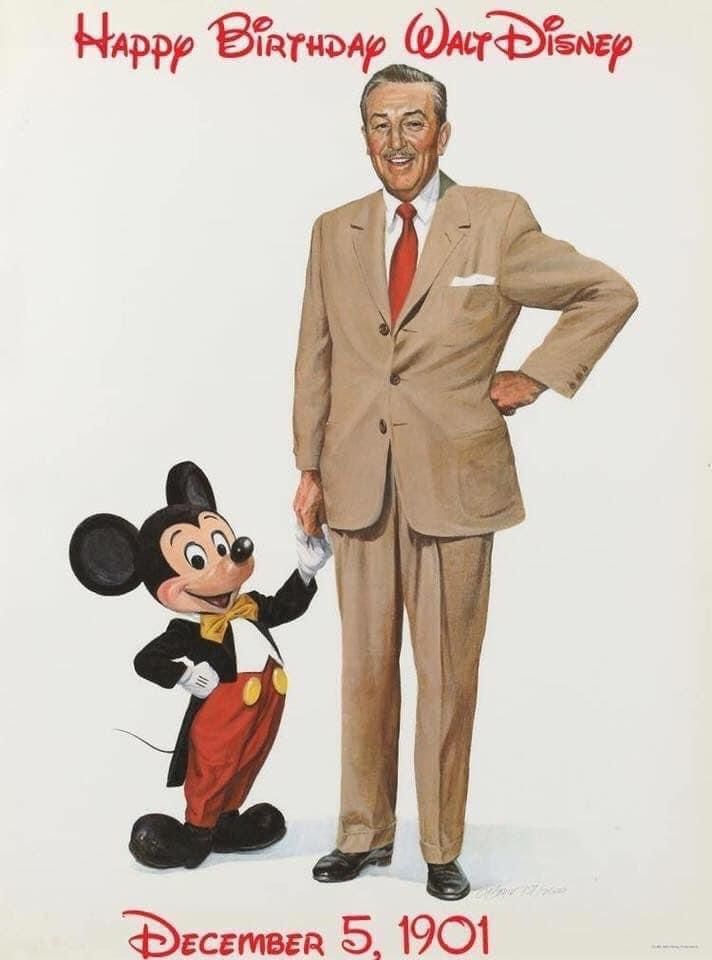 a man in a suit standing next to a mickey mouse