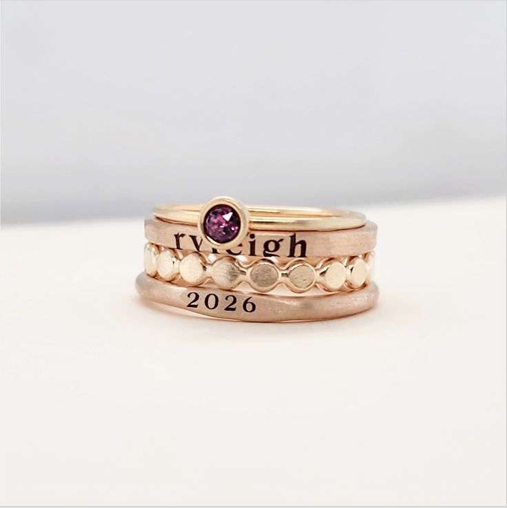 This 14k gold filled signet class ring set is the perfect gift for her, especially for graduation. Handmade and personalized, it adds a unique touch to any outfit. Elevate your style with this elegant and timeless piece. Included in this set is one 14k gold filled 4mm birthstone ring, one 14k gold filled signet ring personalized with a year, one 2mm 14k gold filled personalized name ring, and one 14k gold filled flat beaded ring. This ring set will be engraved in our lowercase serif font and is Heirloom Rose Gold Stackable Rings Stamped 14k, Gold Stackable Signet Ring For Gift, Gold Sterling Silver Stackable Engraved Ring, Hand Stamped Elegant Promise Ring, Elegant Hand Stamped Engraved Ring As A Gift, Classic 14k Gold Filled Stackable Rings Gift, Elegant Adjustable Stackable Rings Stamped 14k, Classic Stackable 14k Gold Filled Rings As Gift, Hand Stamped 14k Gold Engraved Ring